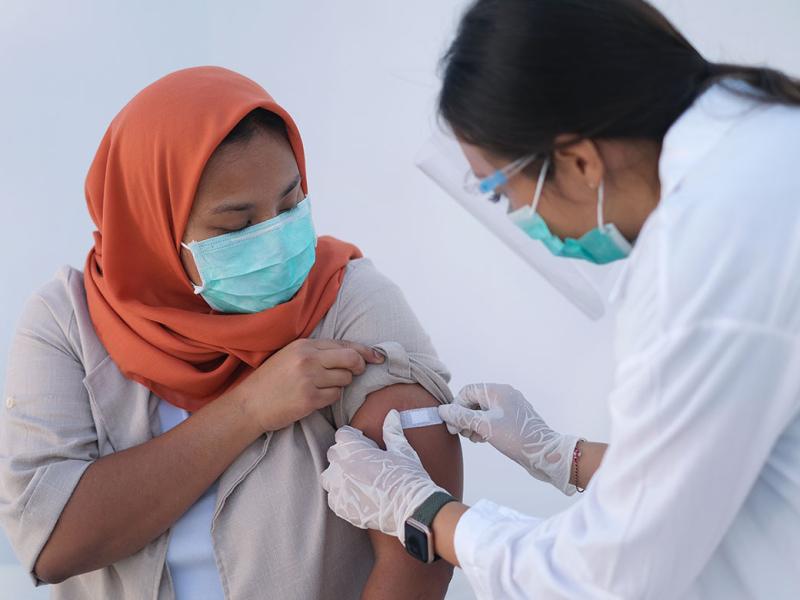 Doctor putting adhesive bandage to patient's arm