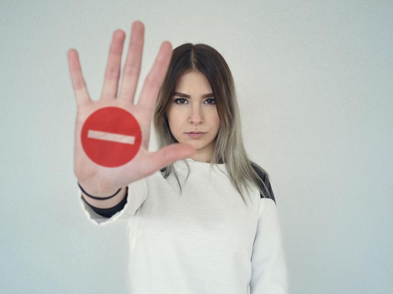 Young woman holding out her hand as a stop sign