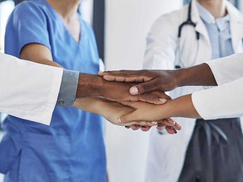 Group of health care workers stacking hands