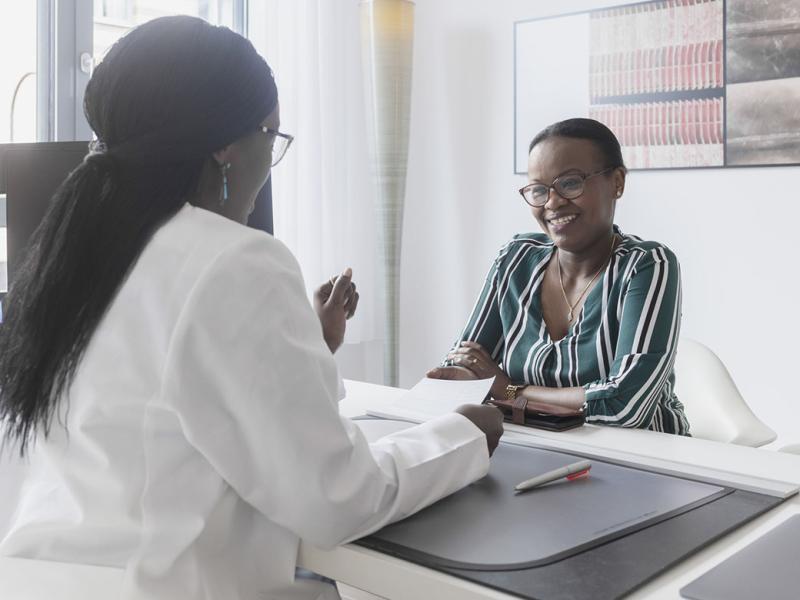 Physician reviewing notes with smiling patient