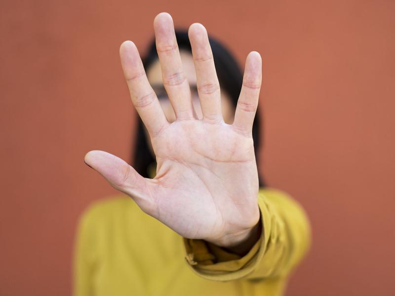 Person with raised hand in a stop gesture