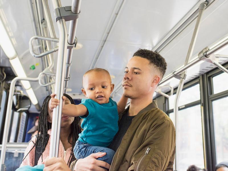 Young mother, father and infant riding city bus