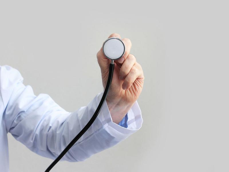 Male in lab coat holding a stethoscope