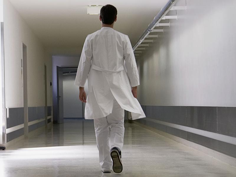 Physician walking down an empty hallway