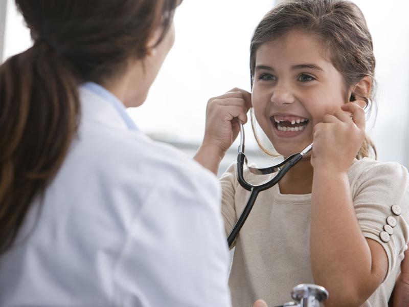 Smiling young patient using stethoscope 