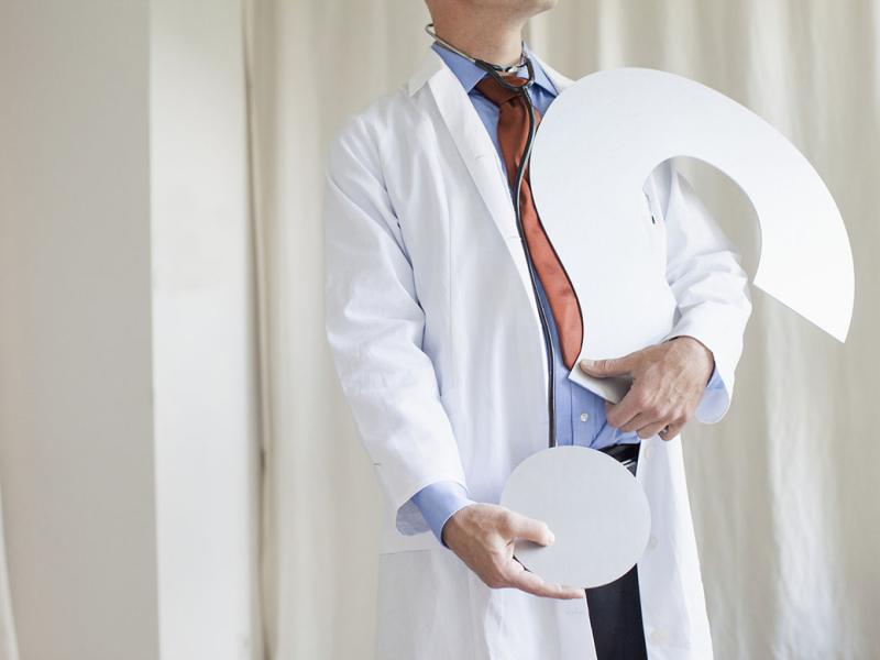 Physician holding a large question mark