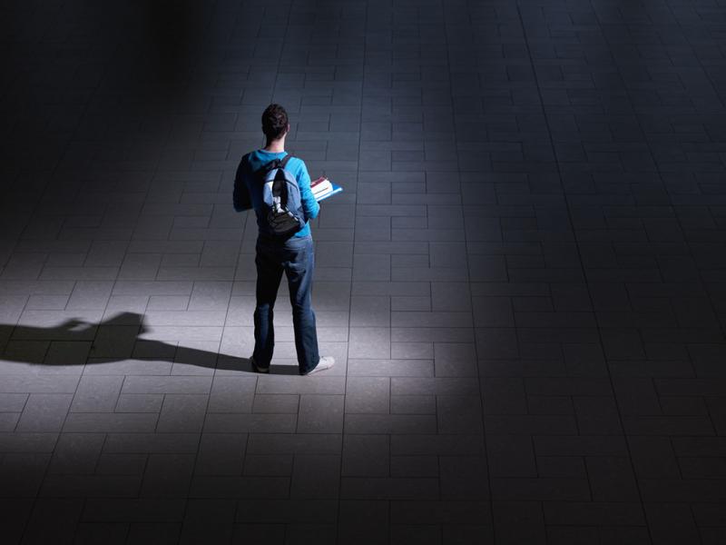 Student standing in a hallway solo