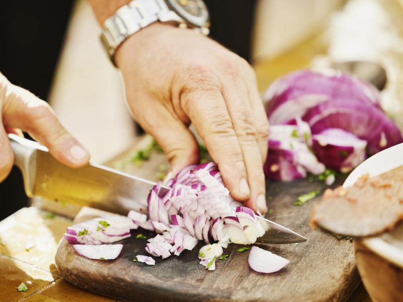 Hands cutting an onion