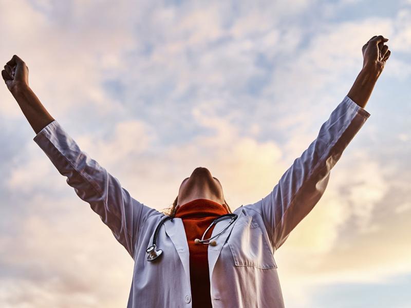 Physician with arms raised to the sky