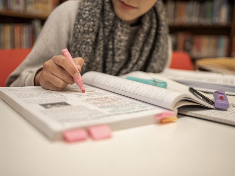 Student highlighting text in a book
