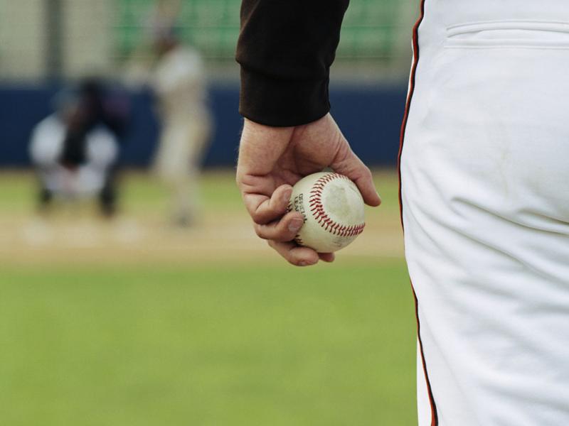Baseball pitcher on mound holding baseball 