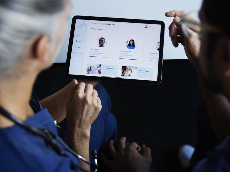 Two doctors looking at patient data on digital tablet 