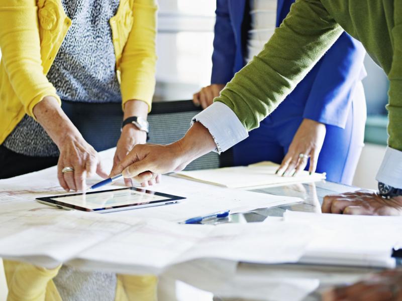 Coworkers discussing project on digital tablet