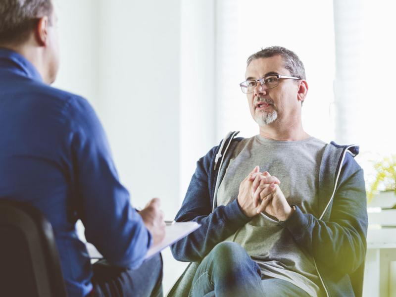 Mature patient talking with psychotherapist in an office