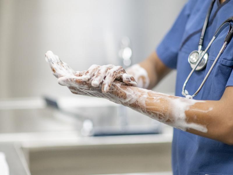 Physician scrubbing hands
