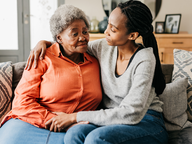 Caregiver comforts elderly woman