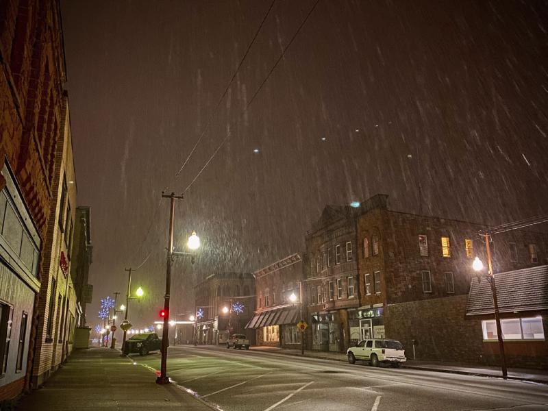 Empty, small town street at night in snow storm