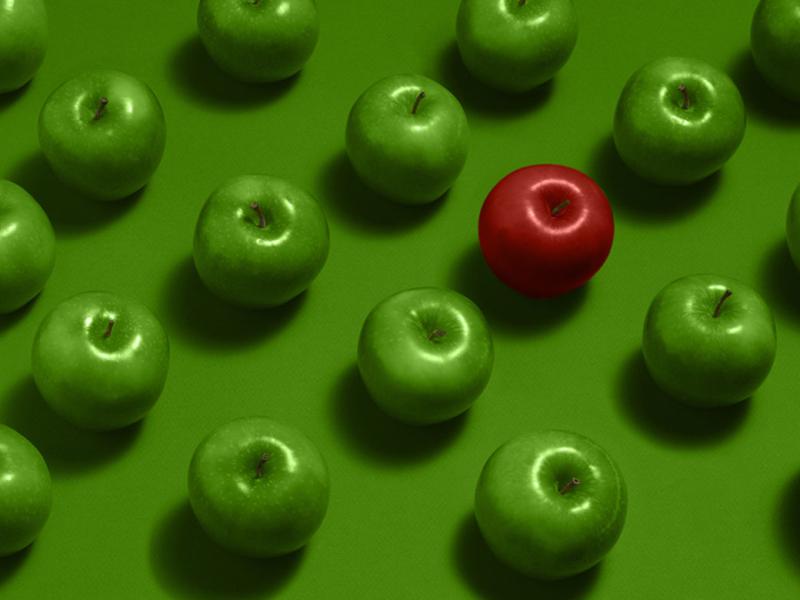 A group of green apples with one red apple