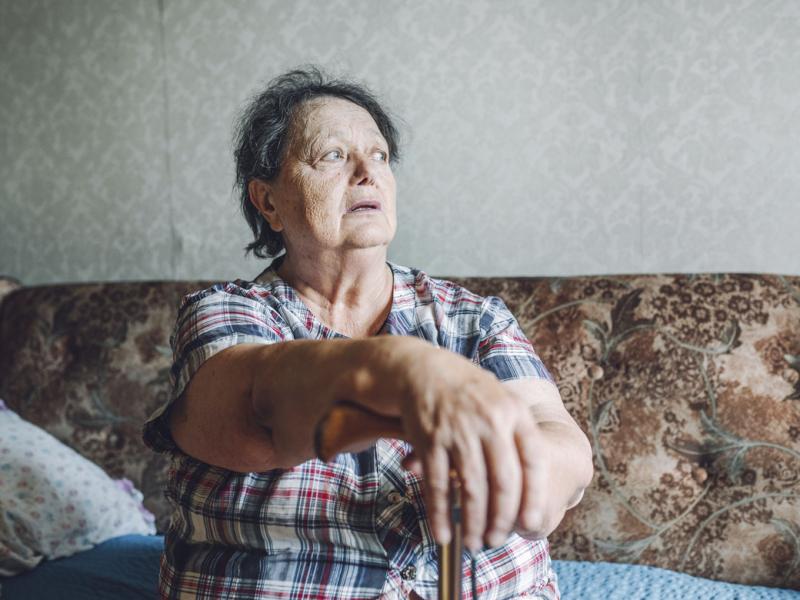 Senior woman leaning on walking cane