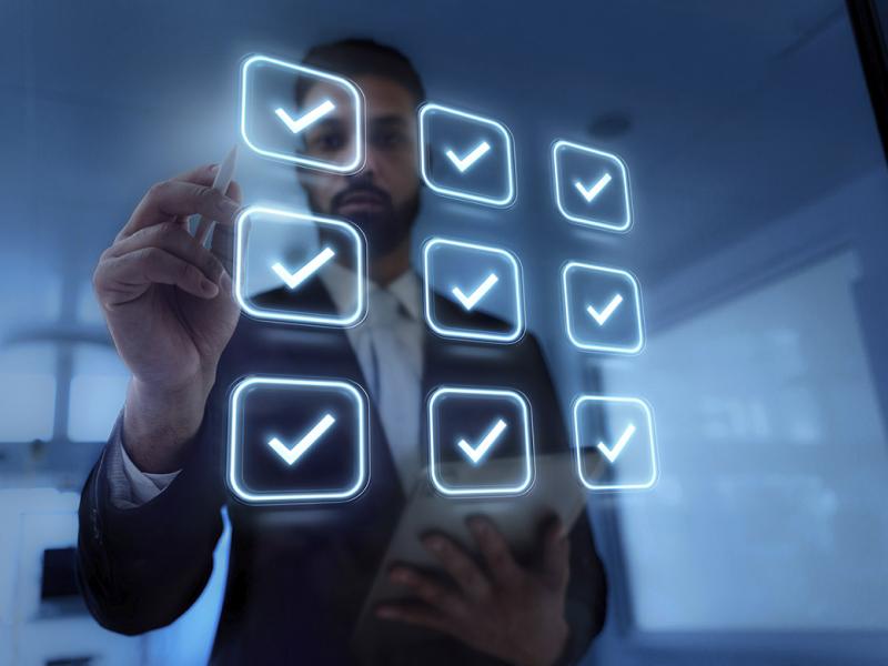 Businessperson stands in front of virtual check boxes