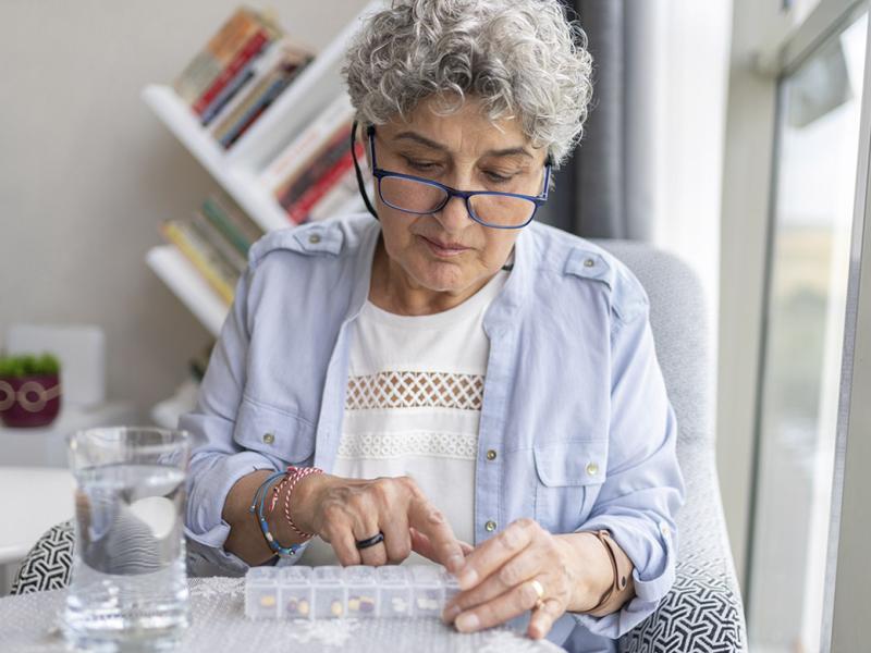 Elderly patient organizes weekly prescriptions