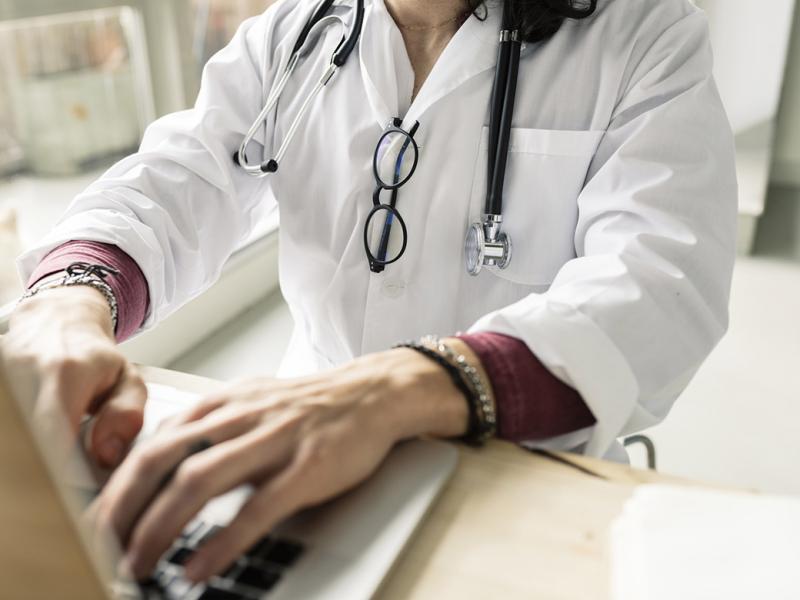 Doctor works at a laptop