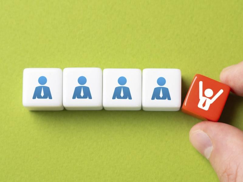 Row of blocks with businesspeople with one being taken away