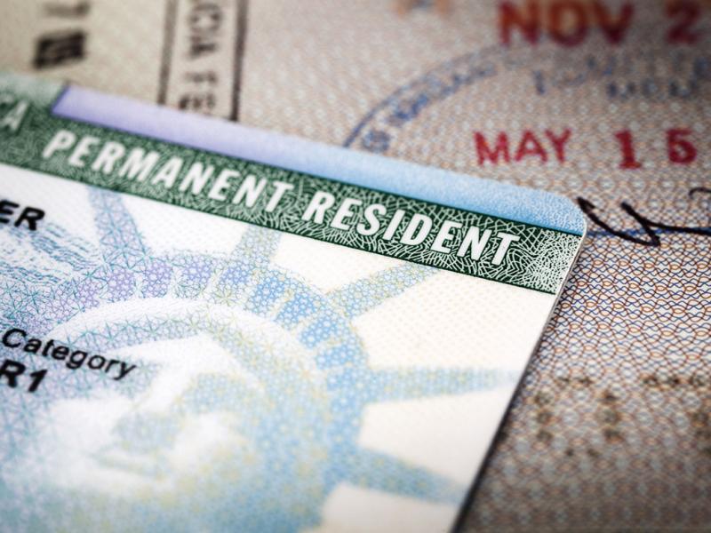 A green card lying on an open passport
