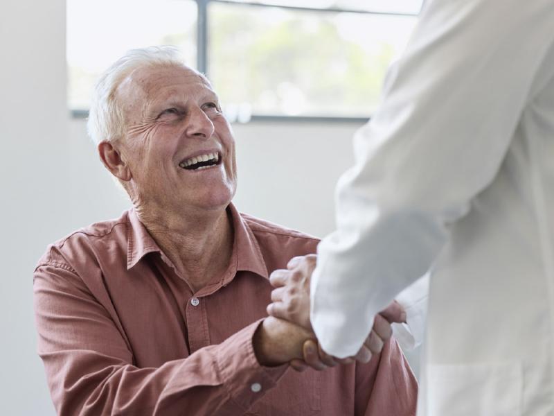 Smiling patient shakes doctor's hand