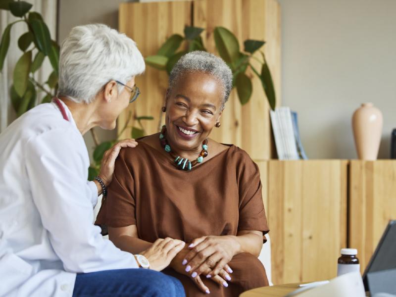 Doctor places reassuring hands on a smiling patient