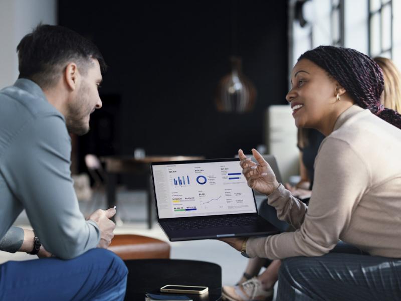 Two colleagues review data on a laptop