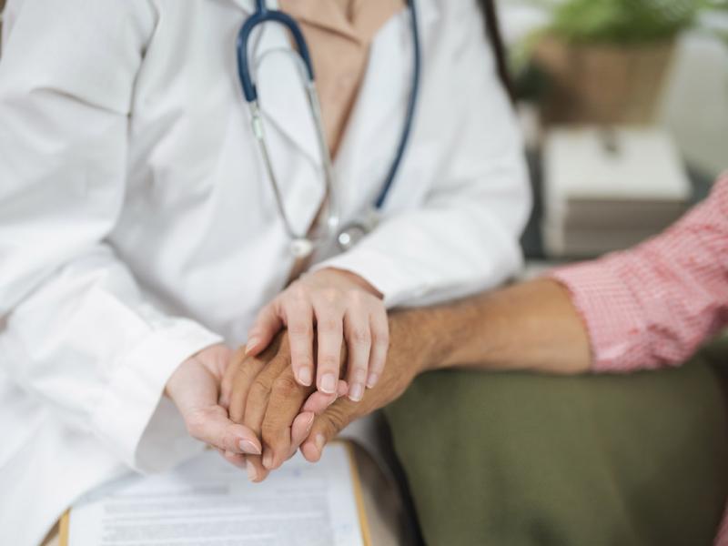Doctor holds patient's hand