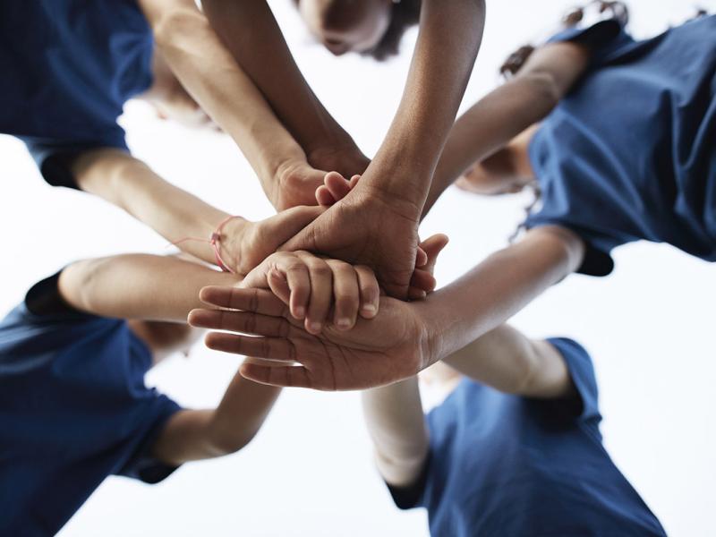 Group of people stack hands in a huddle