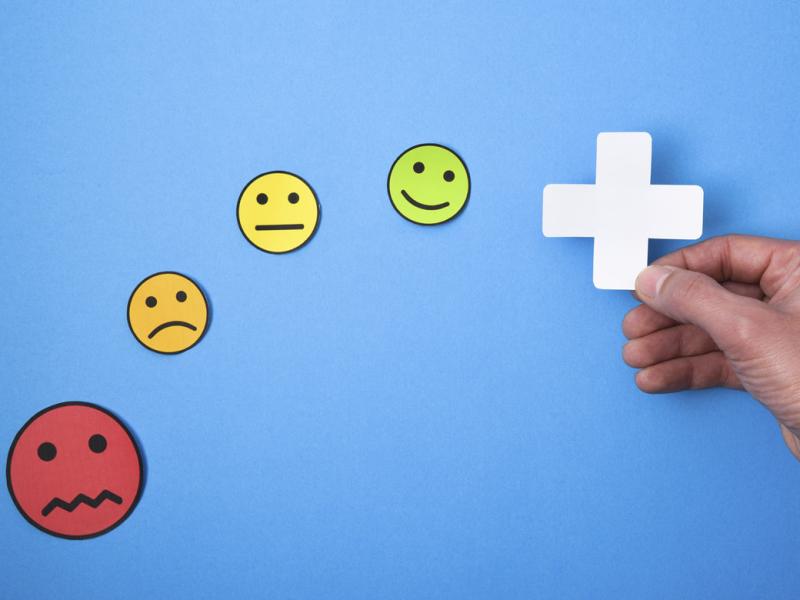 Hand holds a plus sign accompanied by emojis