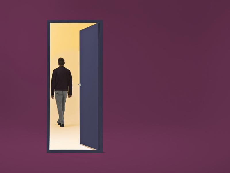 Figure walks through an open door