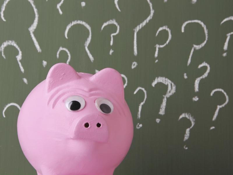 Piggy bank surrounded by question marks