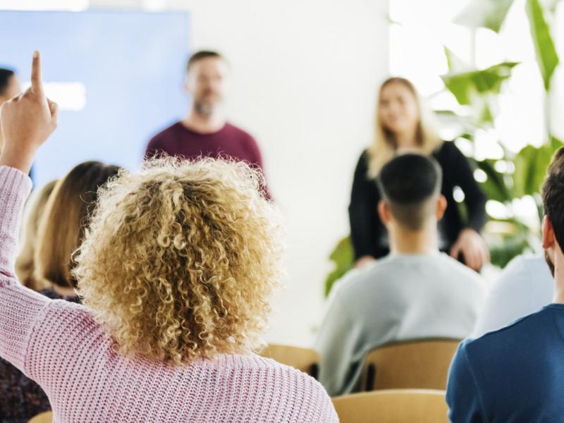 Audience member with hand raised