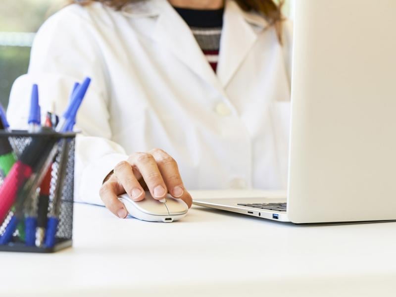 Scientist using laptop and mouse in laboratory