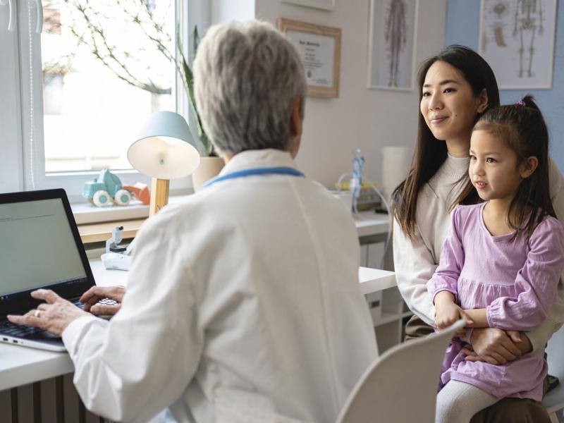 Parent holds child during doctor's appointment