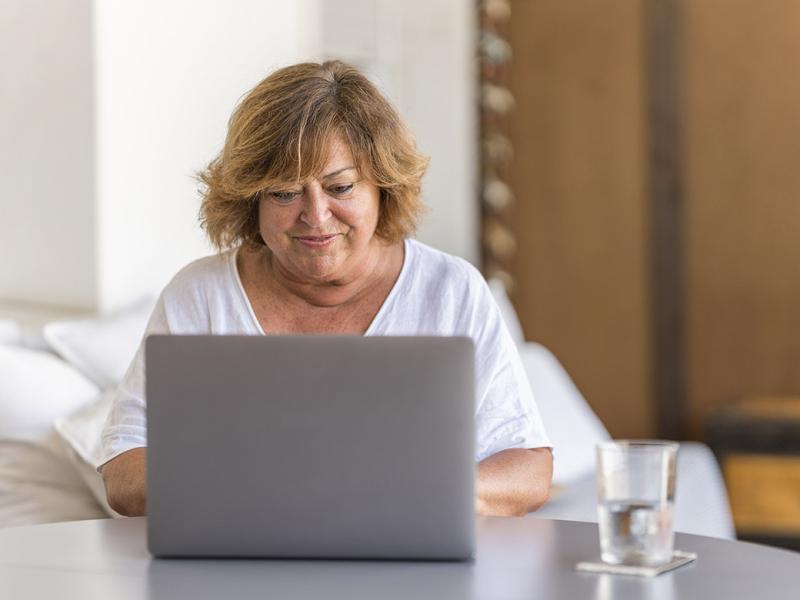Smiling woman works at a laptop