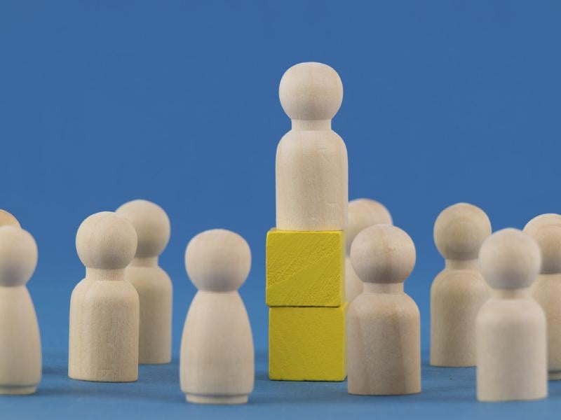 Wooden block elevated among other wooden blocks