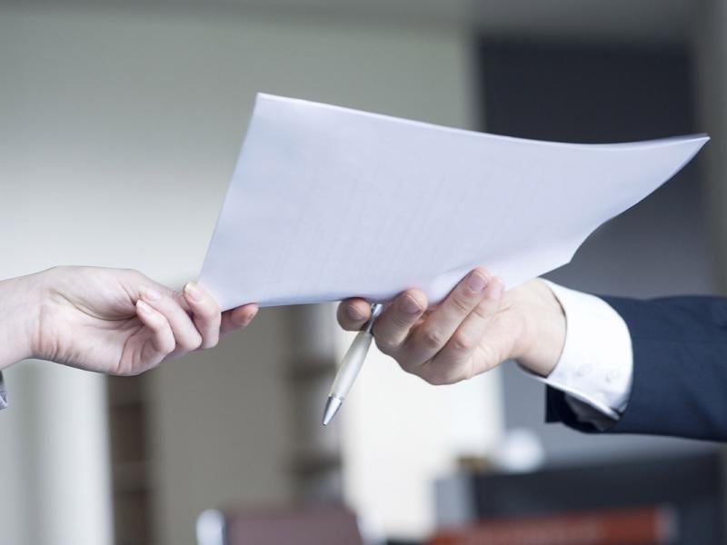 Colleague handing document to another colleague