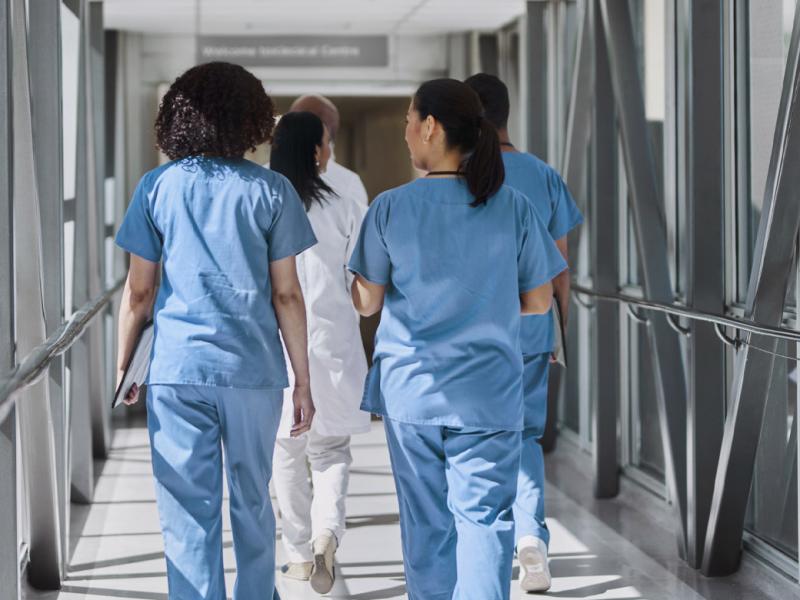 Group of health care workers walk down a hallway
