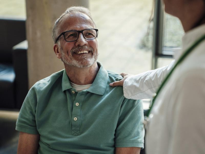 Smiling patient looks up at doctor