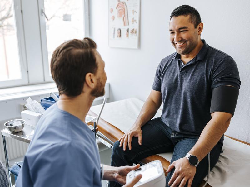 Smiling patient getting blood pressure checked by physician