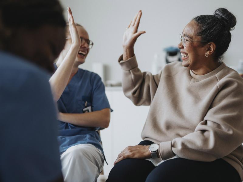 Two smiling people high five