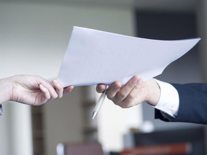 Hand passes a piece of paper to another hand