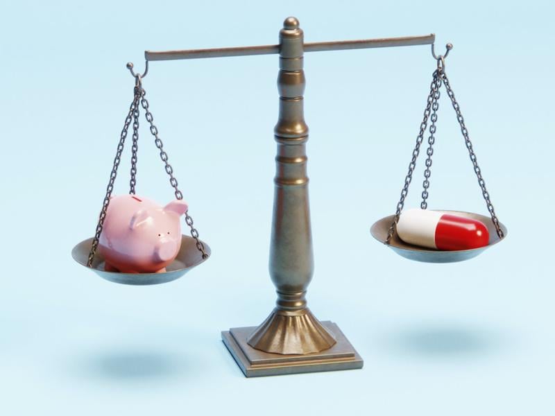 Justice scale with a piggy bank and an oversized pharmaceutical pill 
