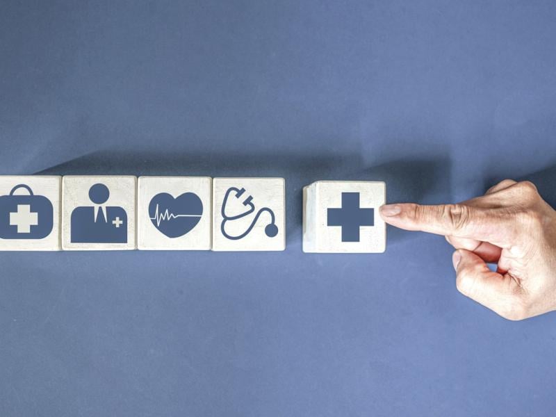 Finger points to blocks with healthcare icons