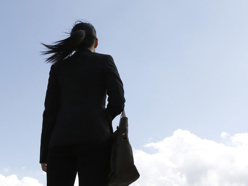 Businessperson looking up sky 